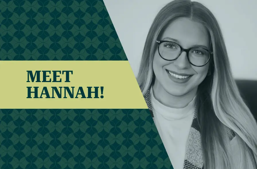 The image features a professional portrait of a woman smiling, with the caption "MEET HANNAH!" on the left side. The text is placed over a light yellow banner, while the background has a geometric dark green pattern. The woman's attire is casual but polished, and the image has a soft focus, giving it a welcoming and friendly tone. This visual is designed to introduce a person, likely for a team or company profile.